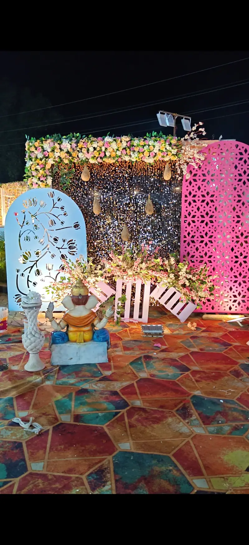 Ganesh statue with decorative flower backdrop
